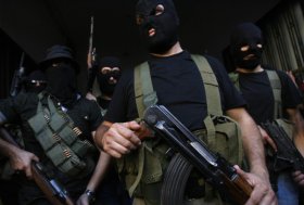 Lebanese masked gunmen from the al-Muqdad clan ready to speak to the press in Beirut's southern suburbs on August 15, 2012. The Muqdads, a large Lebanese Shiite Muslim clan, said it has kidnapped at least 20 Syrians to try to secure the release of a family member abducted near Damascus this week. AFP PHOTO/STR        (Photo credit should read -/AFP/GettyImages)